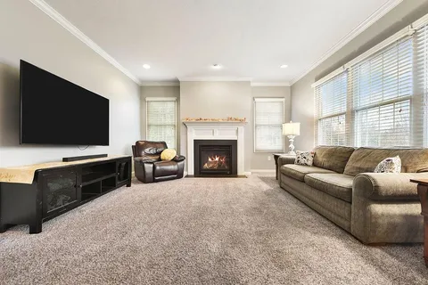 a living room with furniture a flat screen tv and a fireplace