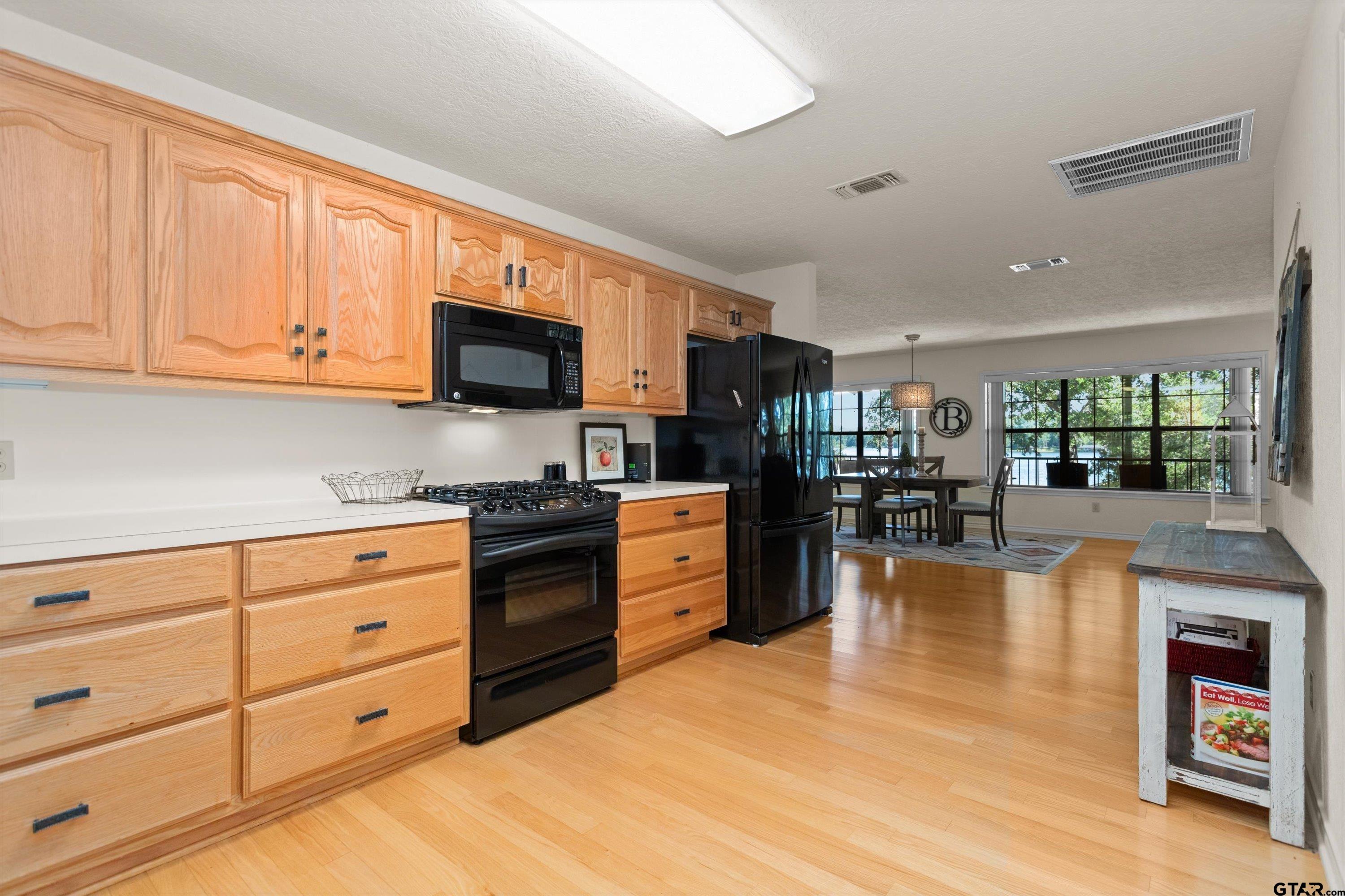 386 Dailey Road Crockett, TX 75835 - Photo 12 of 28 a kitchen with stainless steel appliances granite countertop a stove top oven a sink dishwasher and white cabinets with wooden floor