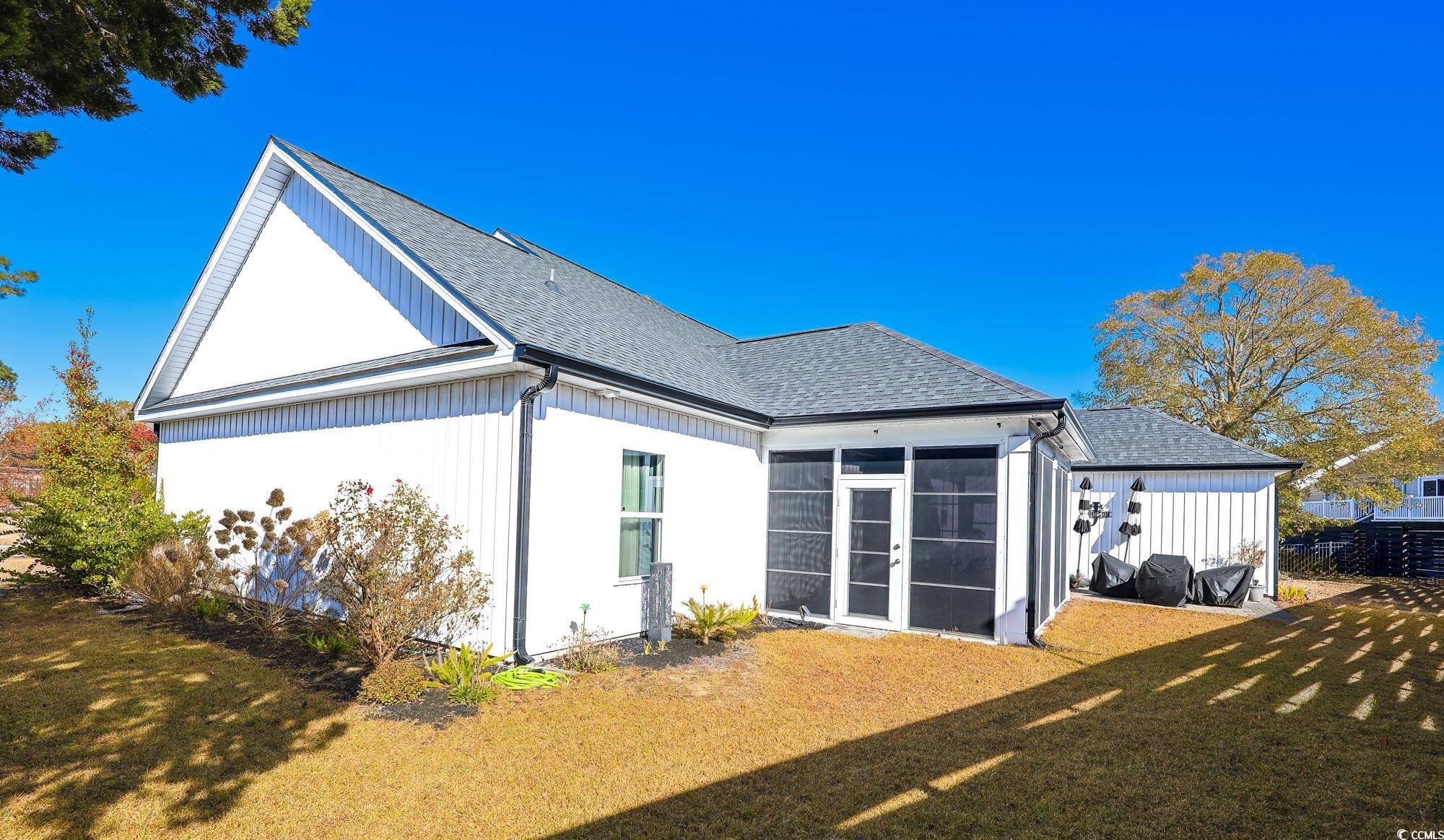 669 Pacific Commons Drive Surfside Beach, SC 29575 - Photo 28 of 36 Back of house with a yard, roof with shingles, and a sunroom