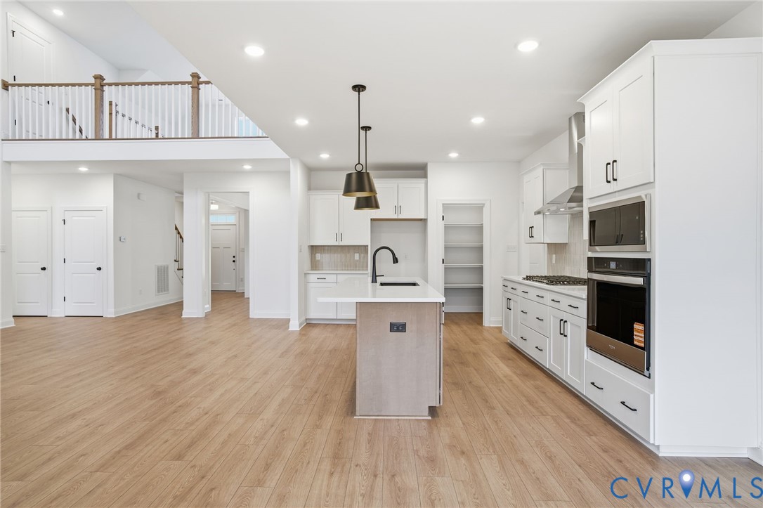 1404 Mill Quarter Road Powhatan, VA 23139 - Photo 12 of 29 a large kitchen with stainless steel appliances kitchen island granite countertop a stove a sink a refrigerator and white cabinets with wooden floor