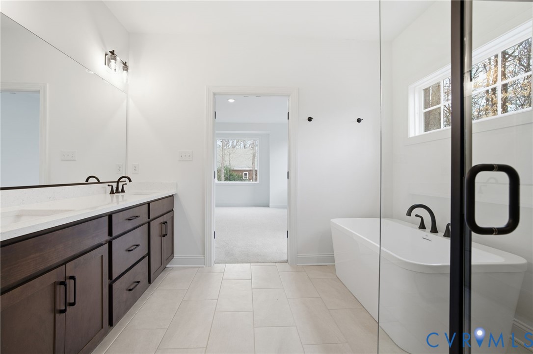 1404 Mill Quarter Road Powhatan, VA 23139 - Photo 15 of 29 a spacious bathroom with a double vanity sink a mirror and a bathtub