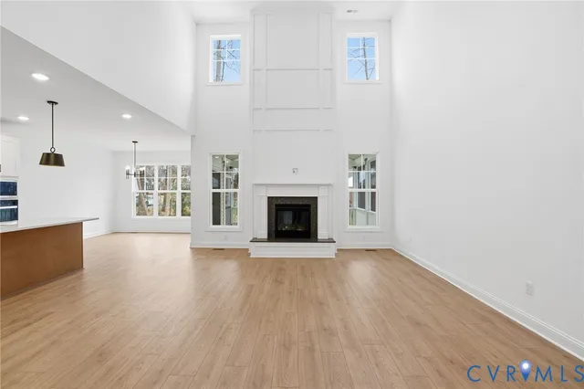 an empty room with wooden floor and a fireplace