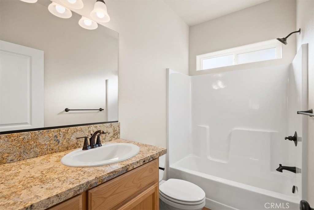 1309 Nunneley Road Paradise, CA 95969 - Photo 19 of 22 a bathroom with a granite countertop sink toilet and shower