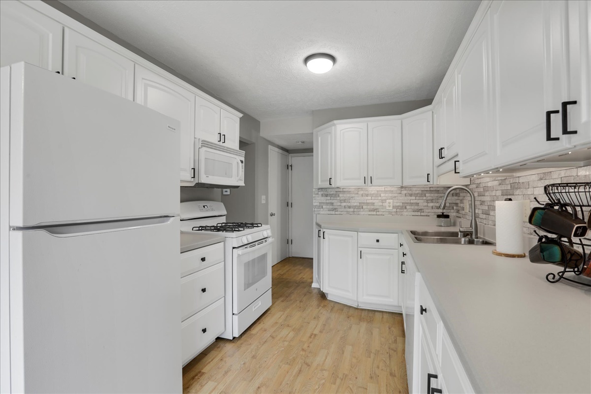 1717 King Drive, Unit B Normal, IL 61761 - Photo 6 of 18 a kitchen with white cabinets and white appliances