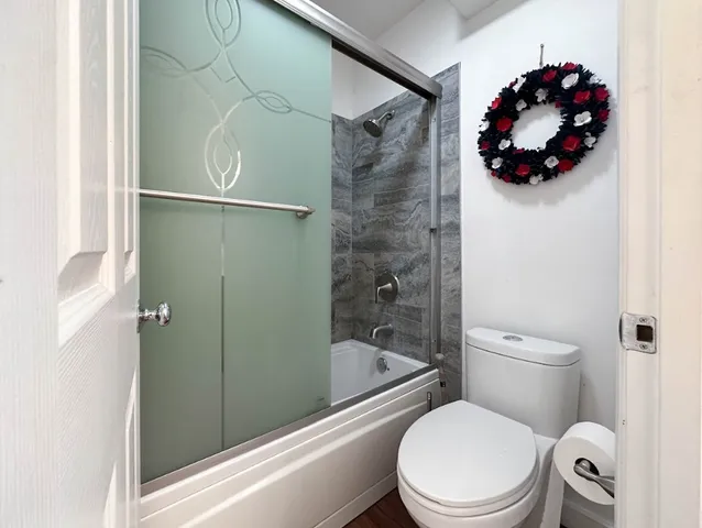 a bathroom with a toilet and a shower