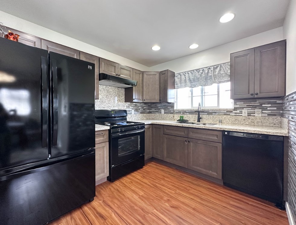 67-1310 Puaena Street Kamuela, HI 96743 - Photo 8 of 26 a kitchen with stainless steel appliances granite countertop a refrigerator a sink dishwasher a stove and white cabinets with wooden floor