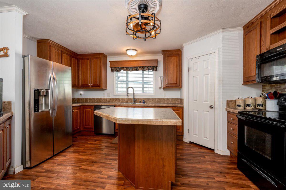302 Berts Drive Lothian, MD 20711 - Photo 17 of 38 a kitchen with stainless steel appliances granite countertop a refrigerator a sink dishwasher a stove and a dining table with wooden floor