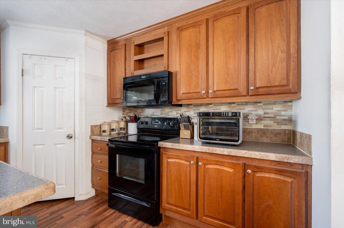 302 Berts Drive Lothian, MD 20711 - Photo 18 of 38 a kitchen with stainless steel appliances granite countertop a stove microwave and refrigerator