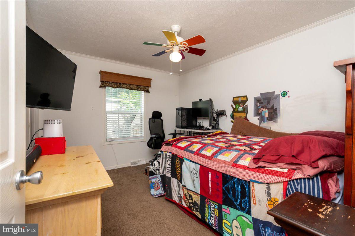 302 Berts Drive Lothian, MD 20711 - Photo 29 of 38 a bedroom with a bed a dresser and flat screen tv