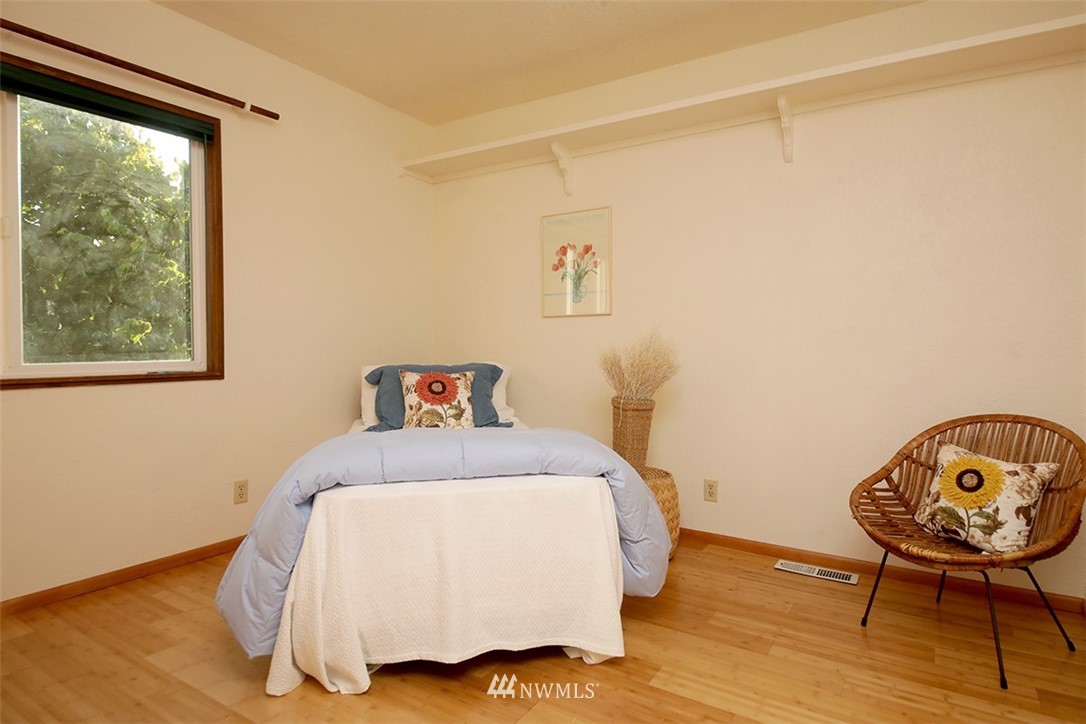 5749 Double Bluff Road Freeland, WA 98249 - Photo 24 of 40 a bedroom with a bed and a lamp on table