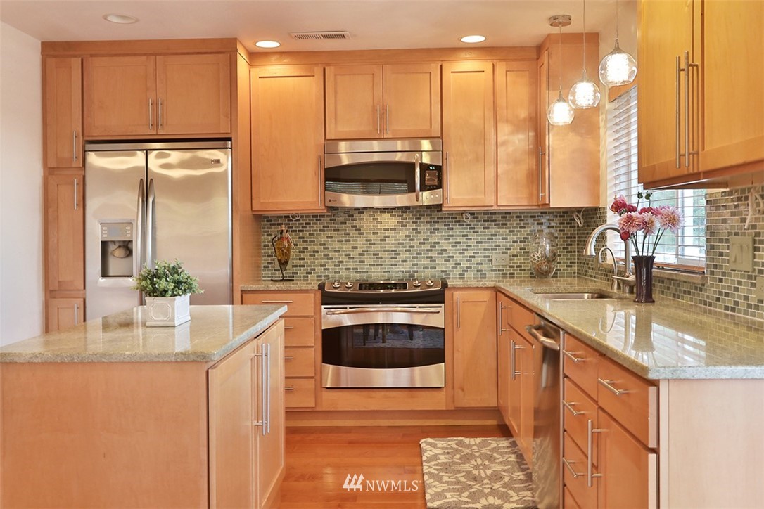 5749 Double Bluff Road Freeland, WA 98249 - Photo 30 of 40 a kitchen with stainless steel appliances granite countertop a sink a stove and a refrigerator