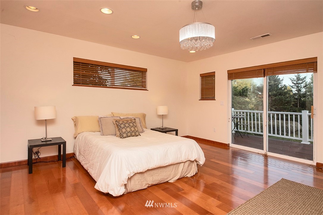 5749 Double Bluff Road Freeland, WA 98249 - Photo 33 of 40 a bedroom with a large bed and a lamp