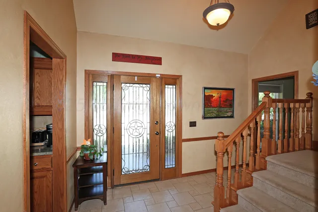 a living room with furniture a large window and wooden floor