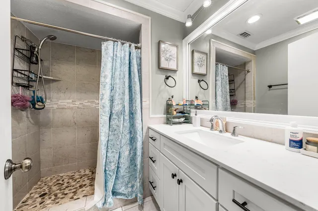 a bathroom with a double vanity sink mirror and shower