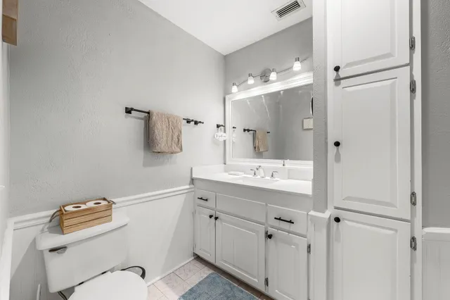 a bathroom with a sink a toilet a mirror and shower