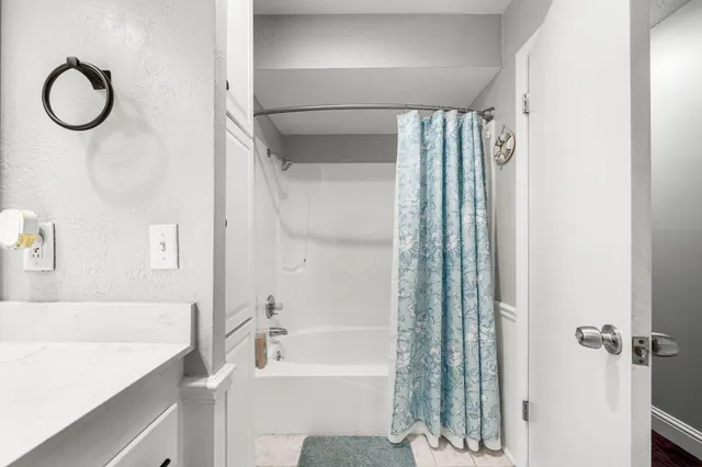 a bathroom with a tub sink vanity and a mirror