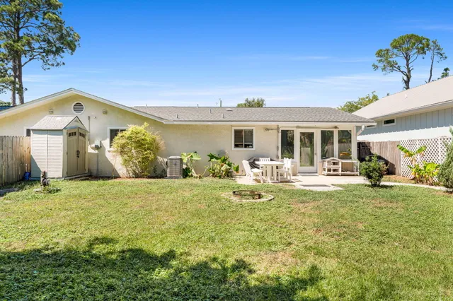 a view of a house with backyard and sitting area