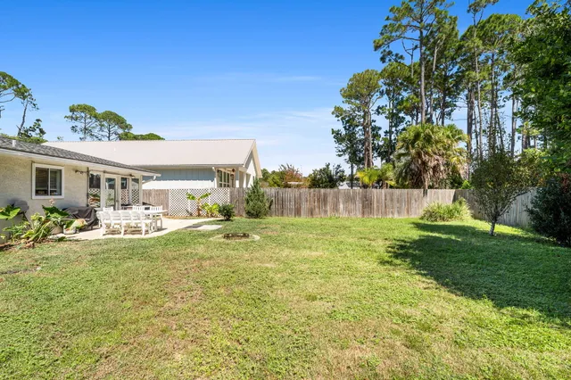 a view of a house with backyard and sitting area