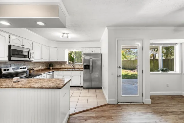 a kitchen with a sink a refrigerator a stove top oven and cabinetry