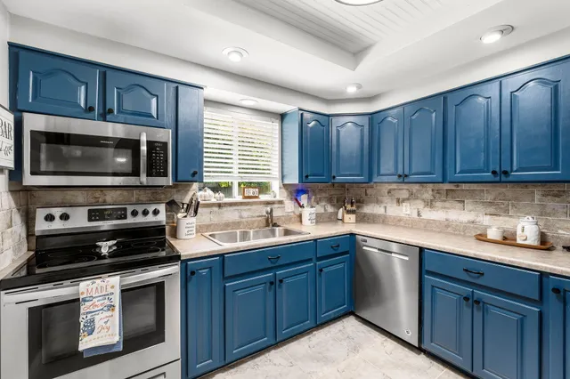 a kitchen with a sink stove oven and wooden cabinets