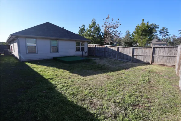 a view of a yard in front of a house with a large tree