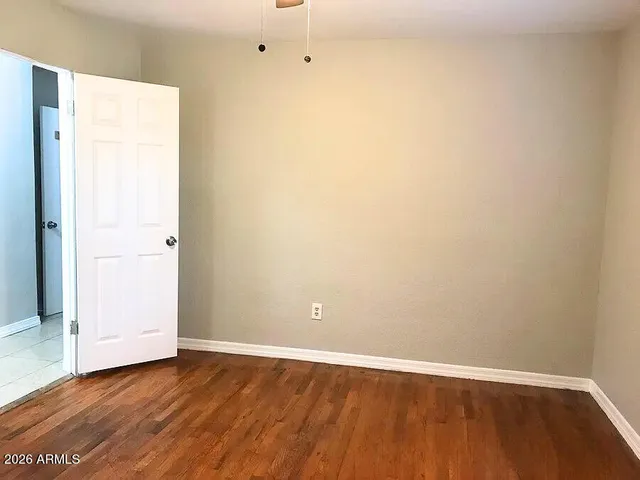 a view of an empty room with wooden floor