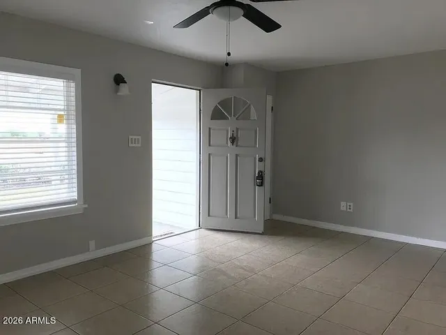 a view of a livingroom with a chandelier fan and windows