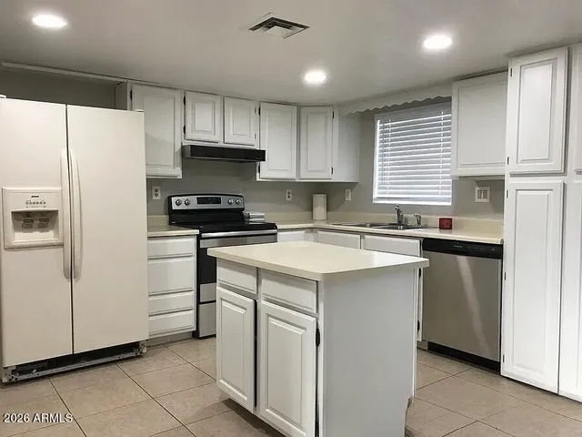 a kitchen with a sink window and cabinets