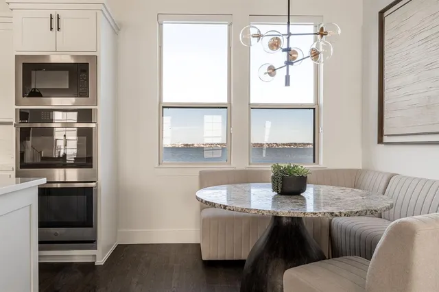 a living room with stainless steel appliances a table and chairs