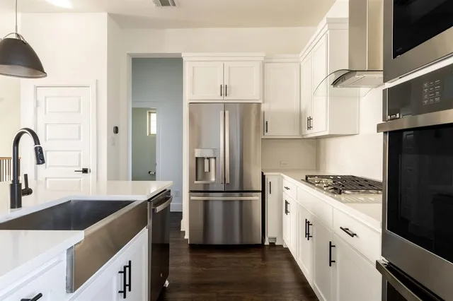 a open kitchen with white cabinets and stainless steel appliances