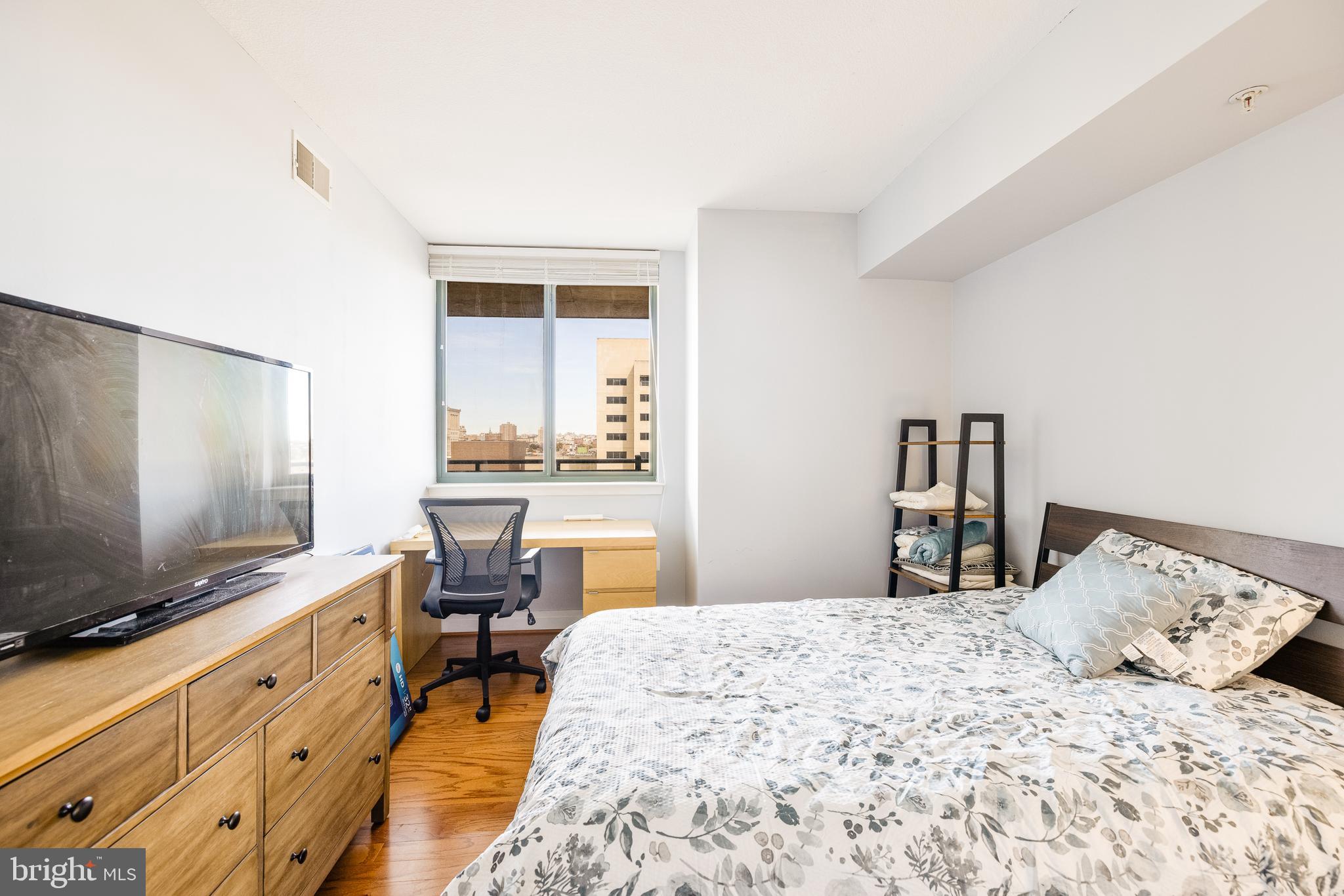 414 Water Street, Unit 1108 Baltimore, MD 21202 - Photo 15 of 36 a bedroom with a bed and a flat screen tv