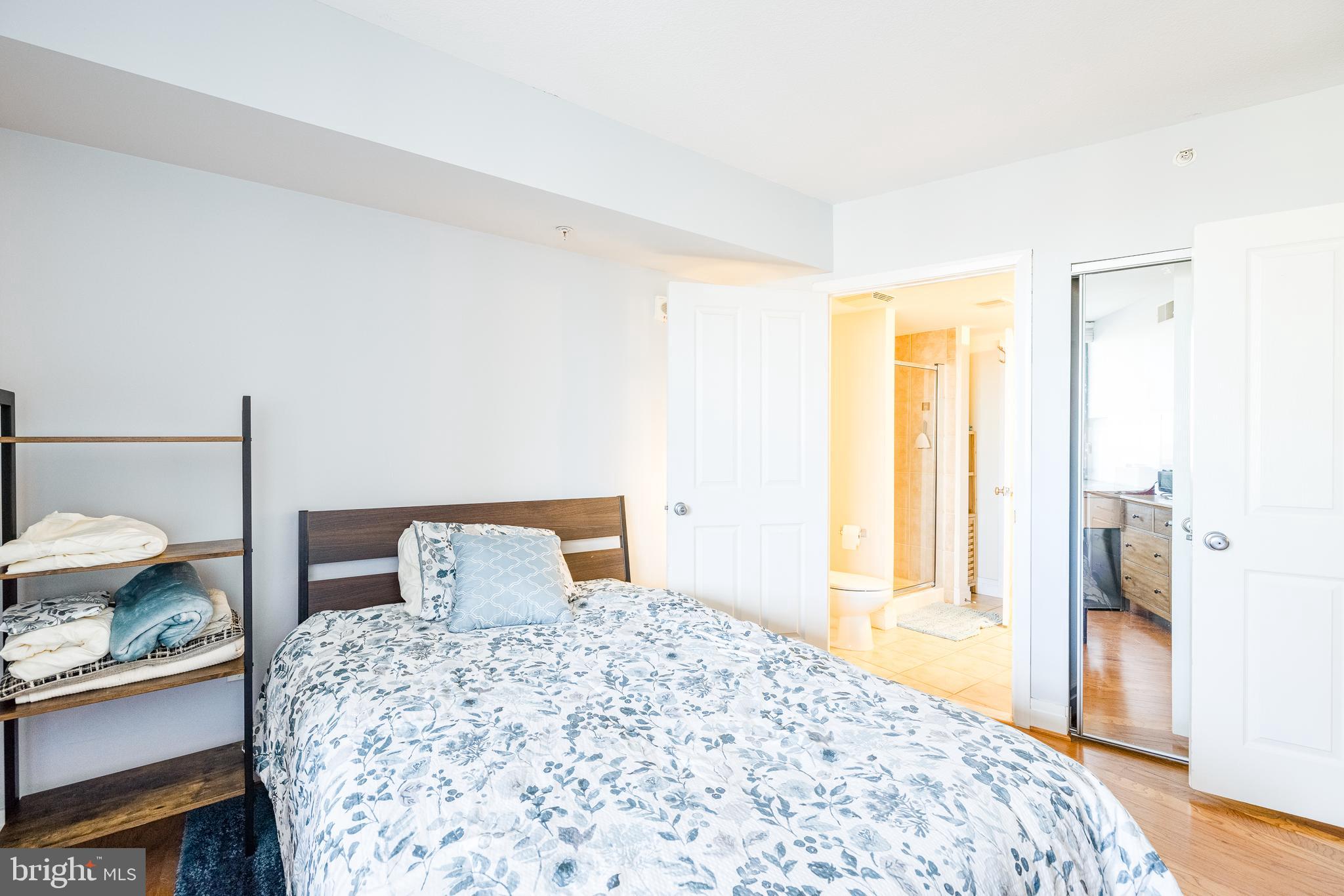 414 Water Street, Unit 1108 Baltimore, MD 21202 - Photo 16 of 36 a bedroom with a bed and wooden floor