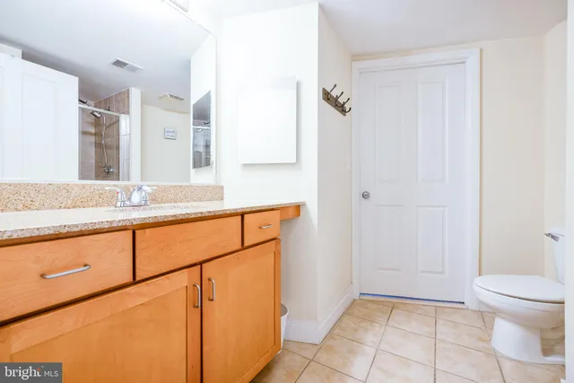 a bathroom with a granite countertop shower and a toilet