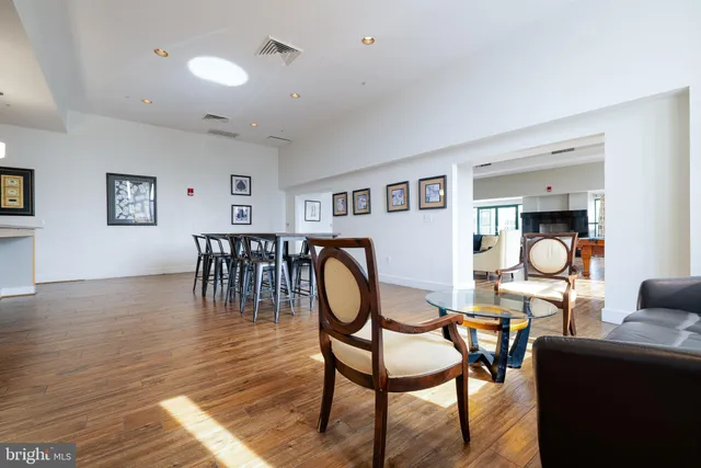 a living room with furniture large window and wooden floor