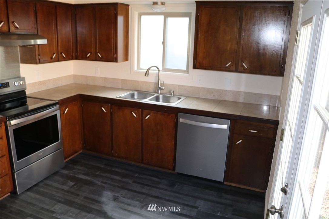 6513 Cady Road Everett, WA 98203 - Photo 5 of 11 a kitchen with granite countertop wooden cabinets a sink and dishwasher