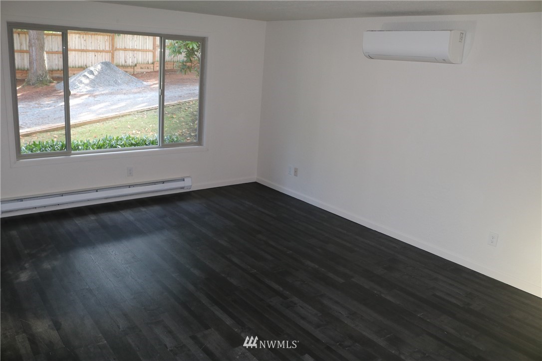 6513 Cady Road Everett, WA 98203 - Photo 6 of 11 an empty room with wooden floor and windows