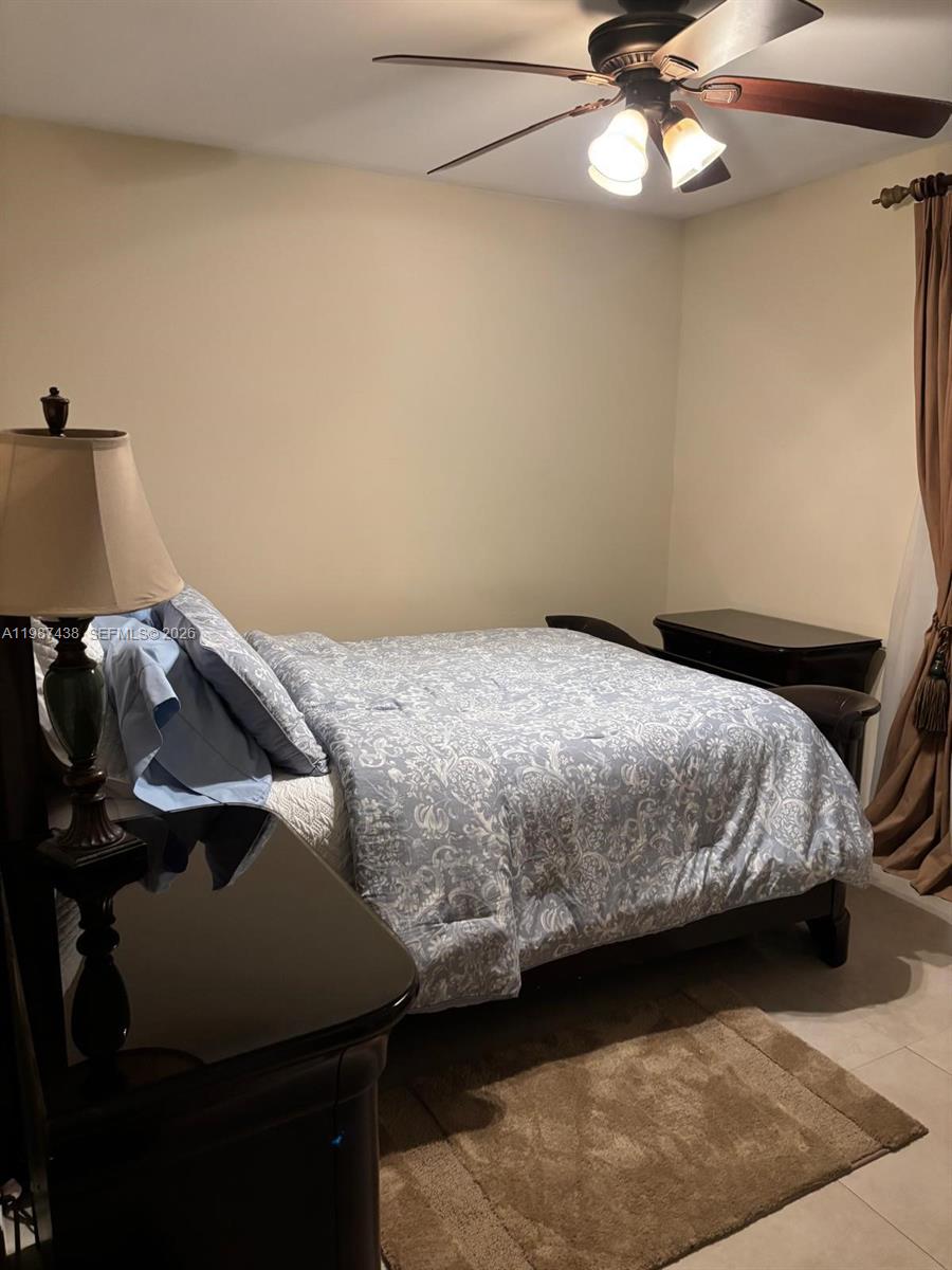 13361 Southwest 88th Terrace, Unit G Miami, FL 33186 - Photo 4 of 4 a bedroom with a bed and ceiling fan