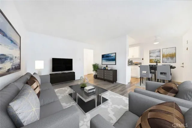 a living room with furniture kitchen view and a flat screen tv