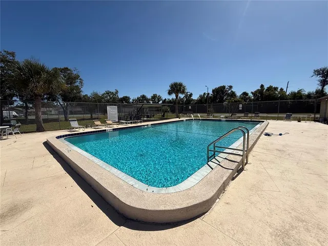 a view of swimming pool with outdoor seating and yard in back
