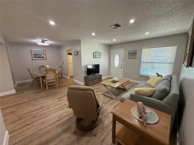 a living room with furniture a wooden floor and a fireplace