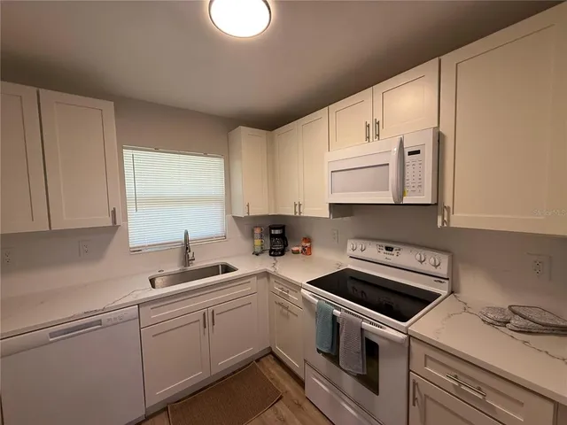 a kitchen with a sink stove top oven and cabinets