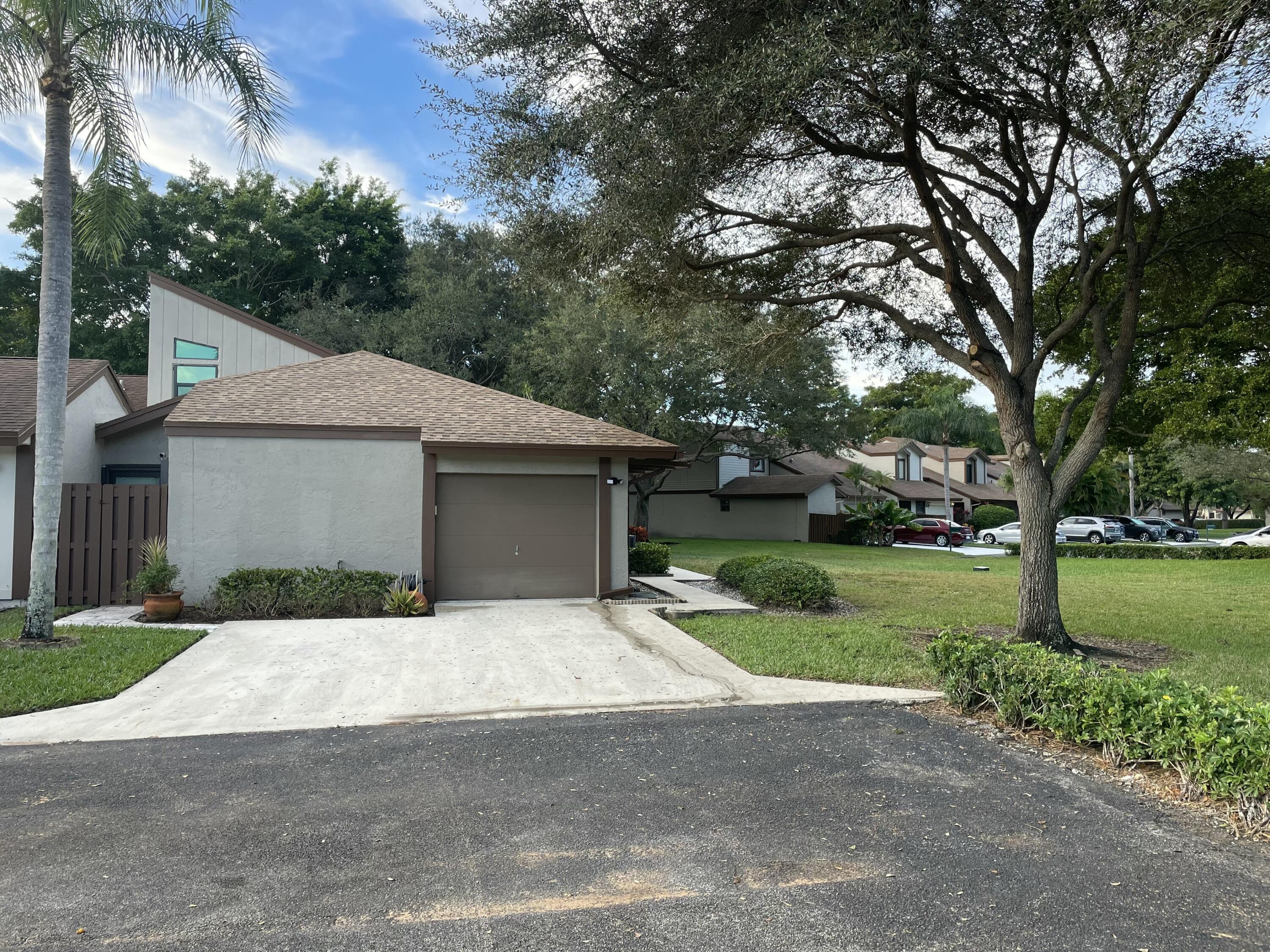 22305 Whistling Pines Lane Boca Raton, FL 33428 - Photo 1 of 16 a front view of house with yard and trees