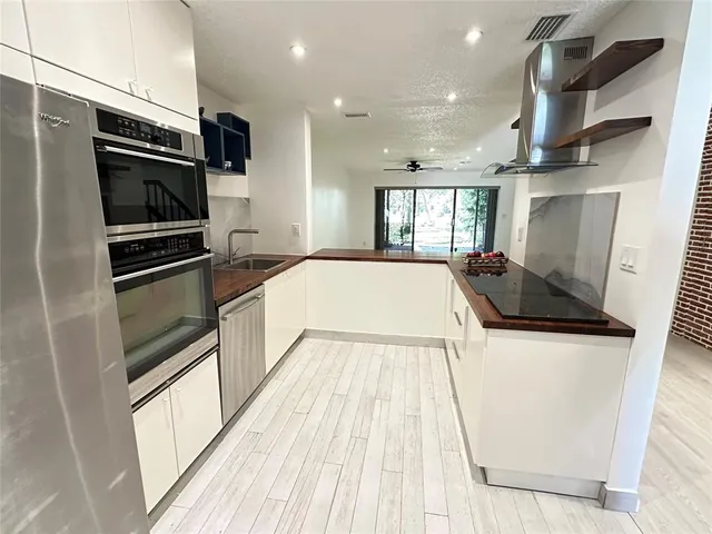 a kitchen with granite countertop a refrigerator stove and microwave