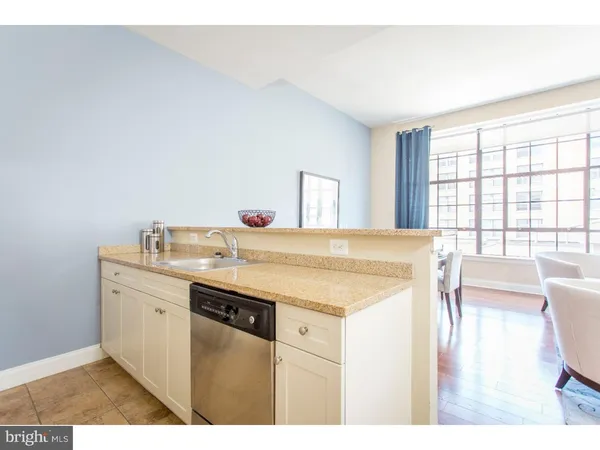 a spacious bathroom with a granite countertop sink a toilet a mirror and a tub
