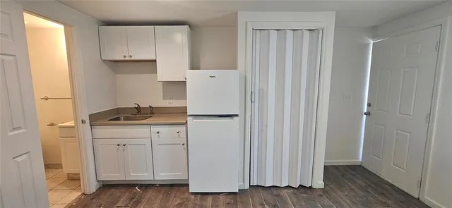 a kitchen with white cabinets and white appliances