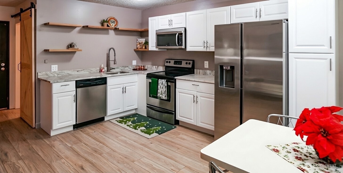 220 Tanner Way, Unit 206 Snoqualmie Pass, WA 98068 - Photo 15 of 37 a kitchen with stainless steel appliances granite countertop a refrigerator a stove and a wooden floors
