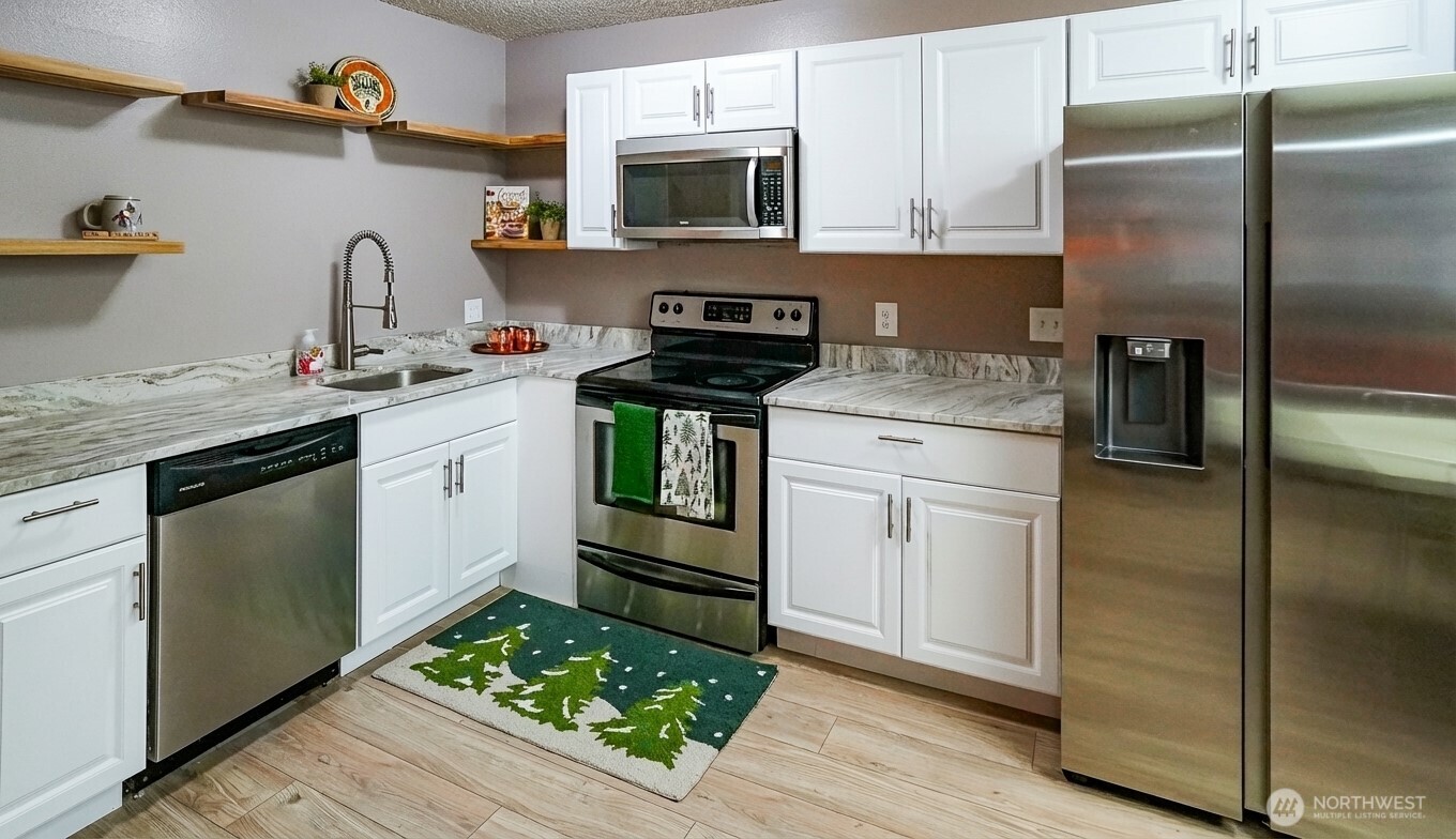 220 Tanner Way, Unit 206 Snoqualmie Pass, WA 98068 - Photo 16 of 37 a kitchen with granite countertop stainless steel appliances and wooden cabinets