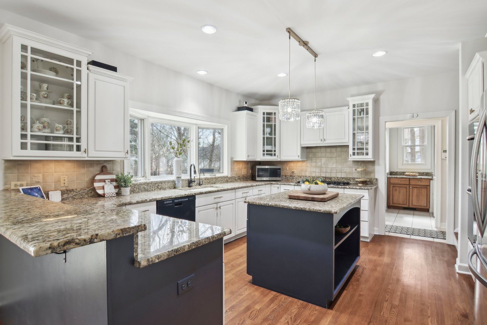 1005 Bridle Lane Cary, IL 60013 - Photo 13 of 64 a kitchen with granite countertop kitchen island wooden floors and stainless steel appliances
