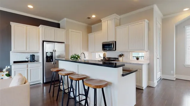 a kitchen with white cabinets and stainless steel appliances