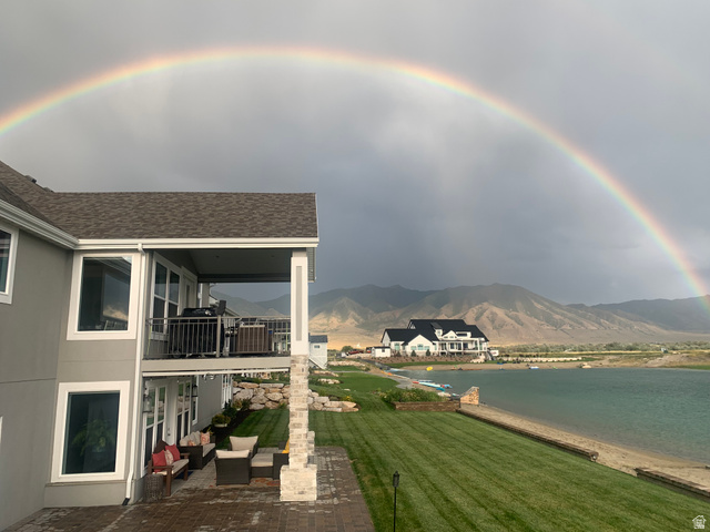 21 Pier Place Tooele, UT 84074 - Photo 102 of 112 Lakefront property featuring a terraced backyard, manicured lawn, and a stone-paved patio